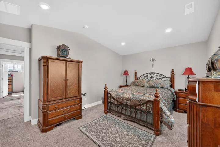 Carpeted bedroom featuring recessed lighting, neutral wall tones, and an arched doorway