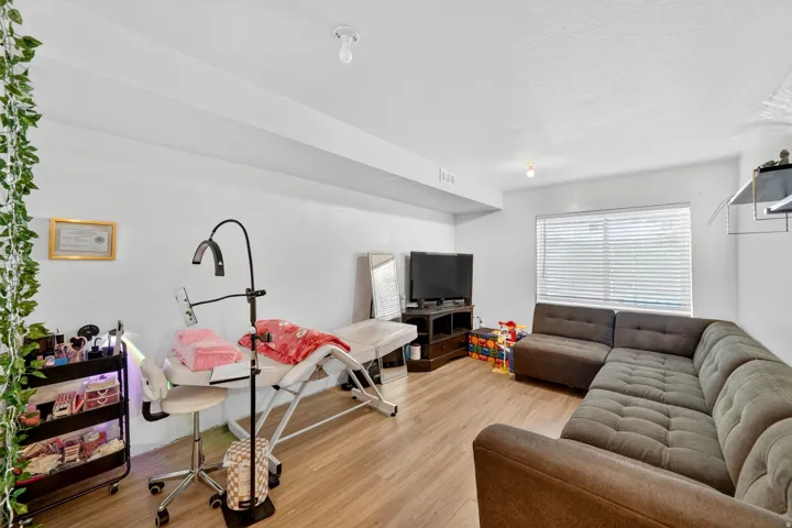 Spacious room with wood-finish flooring and white walls