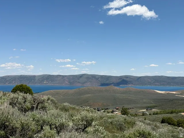 Expansive mountain and water scenery featuring distant blue water and rolling hills