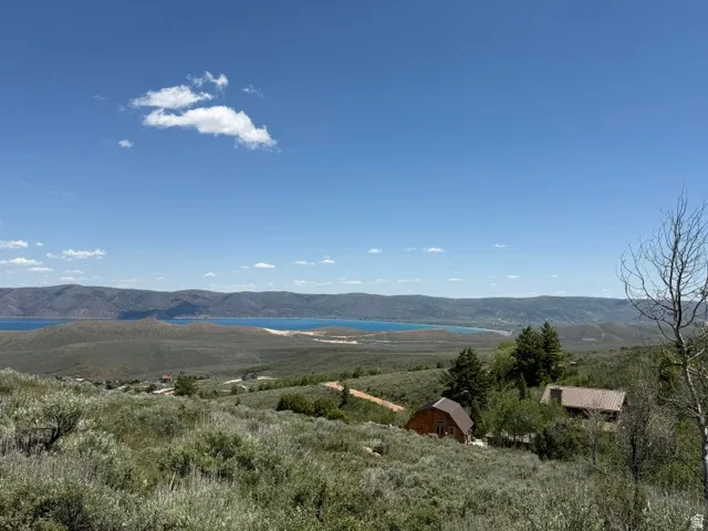 Expansive landscape featuring a distant body of water and rolling hills