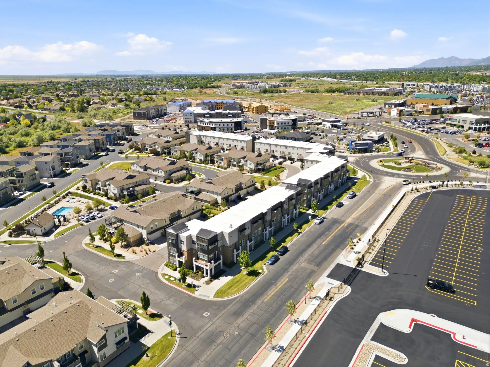 Expansive aerial perspective showcasing a mixed-use development with residential properties and commercial establishments