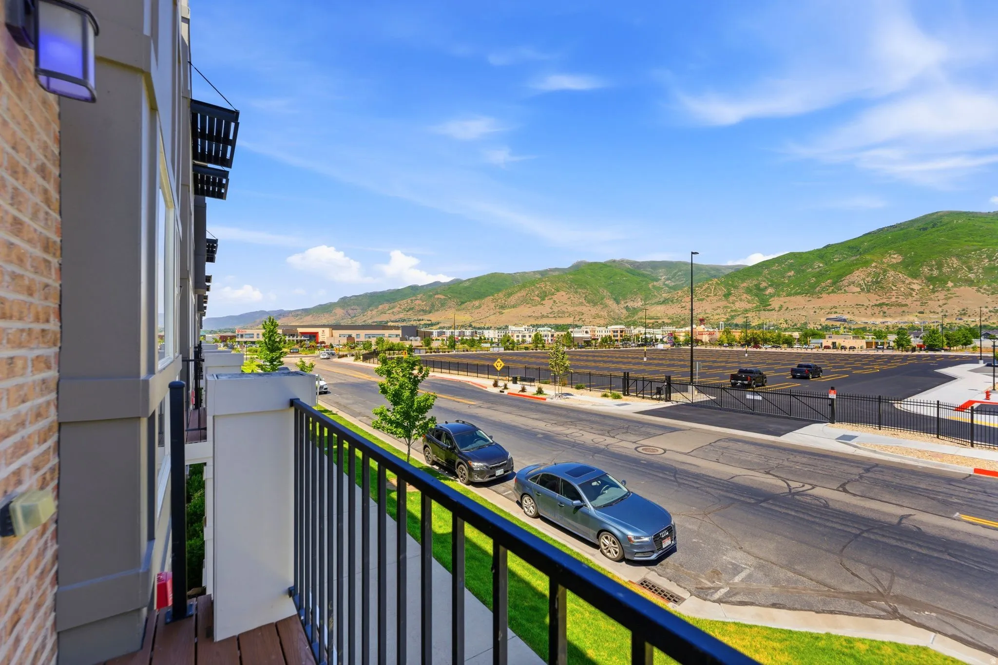 Private balcony featuring wood-finish flooring and black metal railings