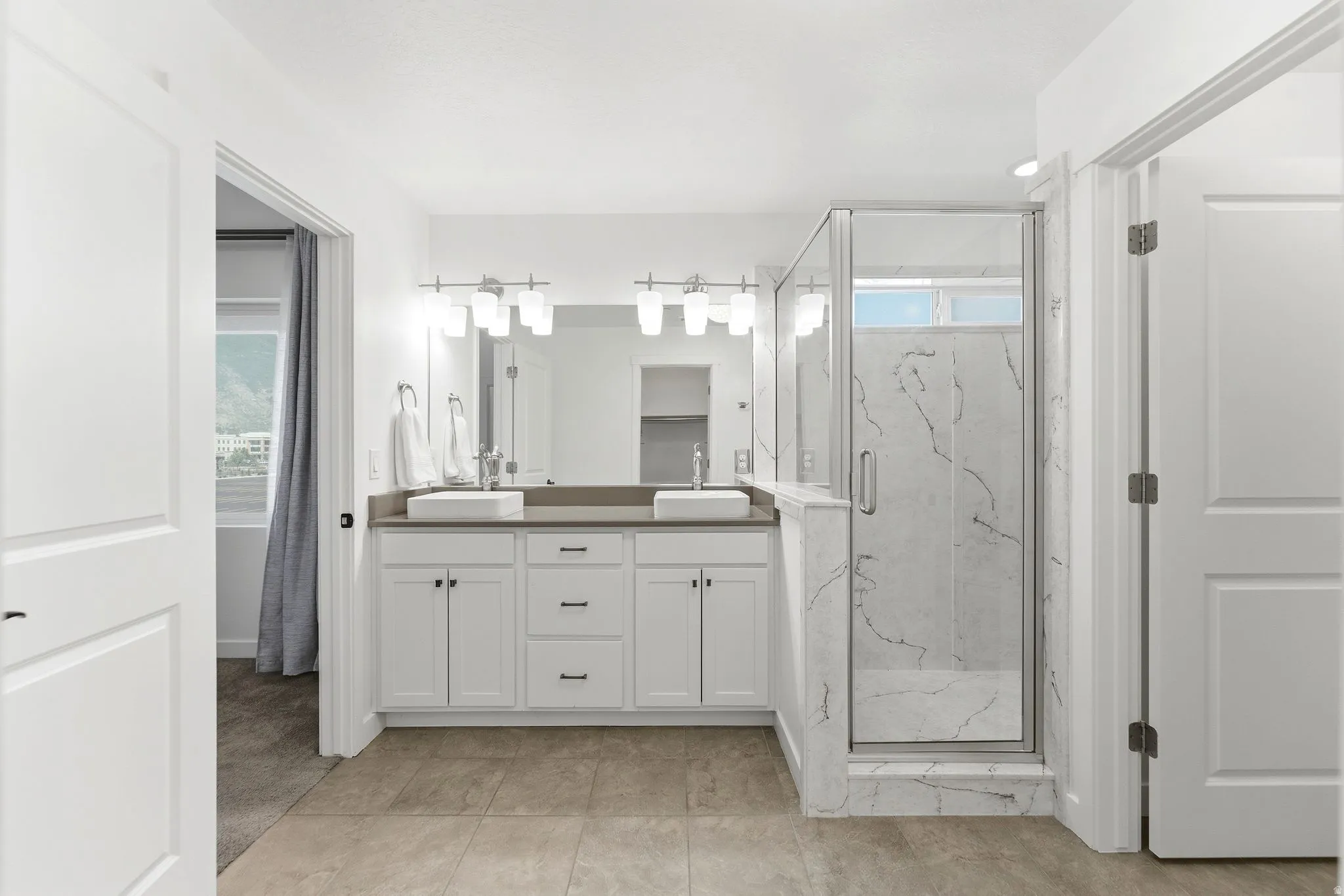 Dual vanity with undermount sinks and contemporary light fixtures