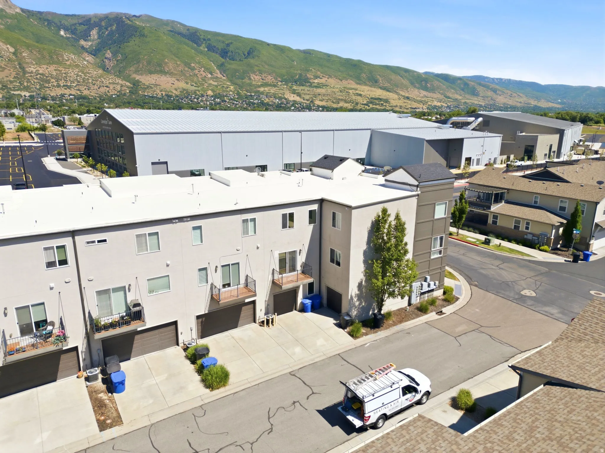 Modern townhome-style residences featuring light-toned exteriors, attached garages, and private balconies