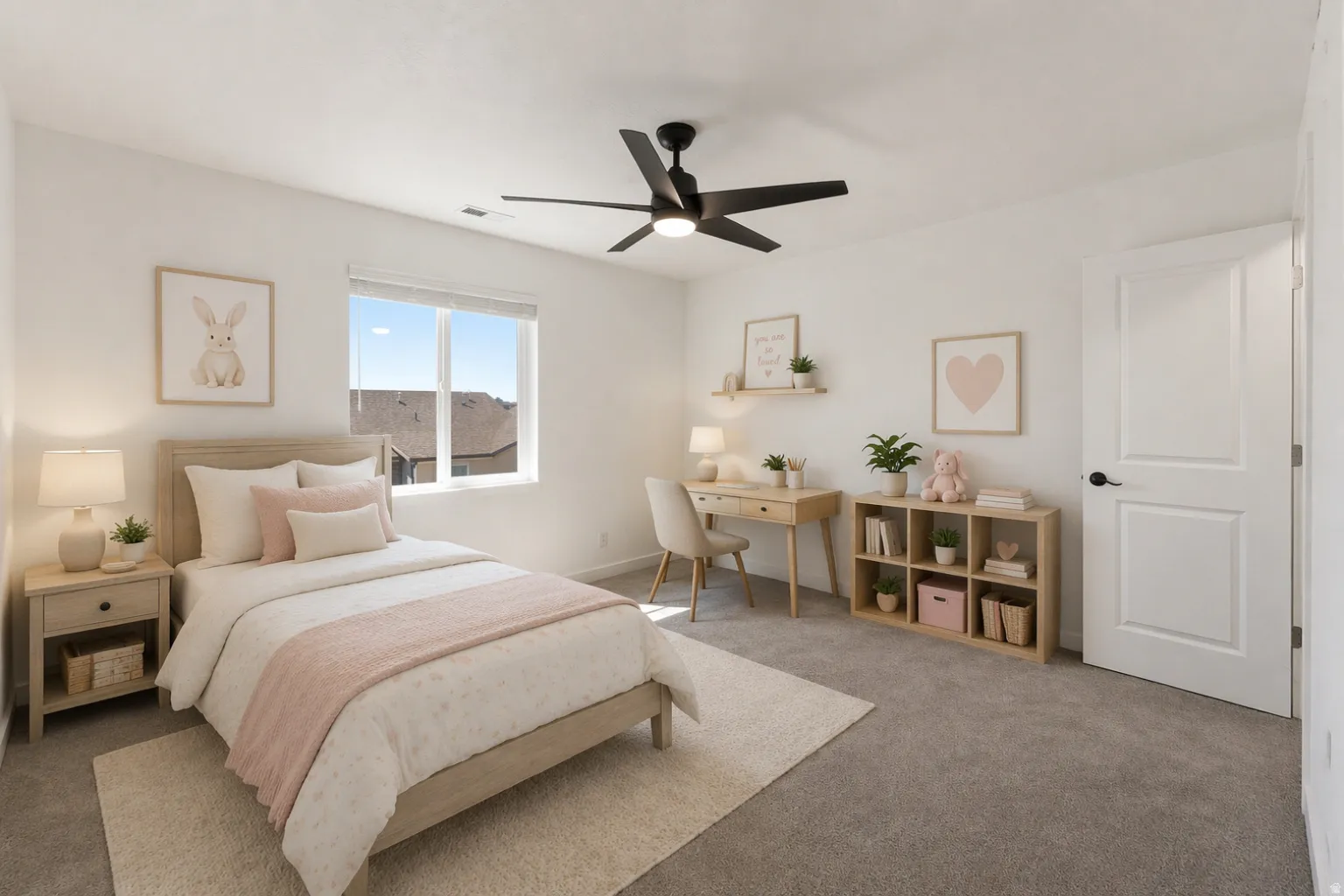 Carpeted room featuring a ceiling fan, a window with blinds, a white paneled door with a black handle, a light wood-finish nightstand, and a light wood-finish desk with a matching shelf