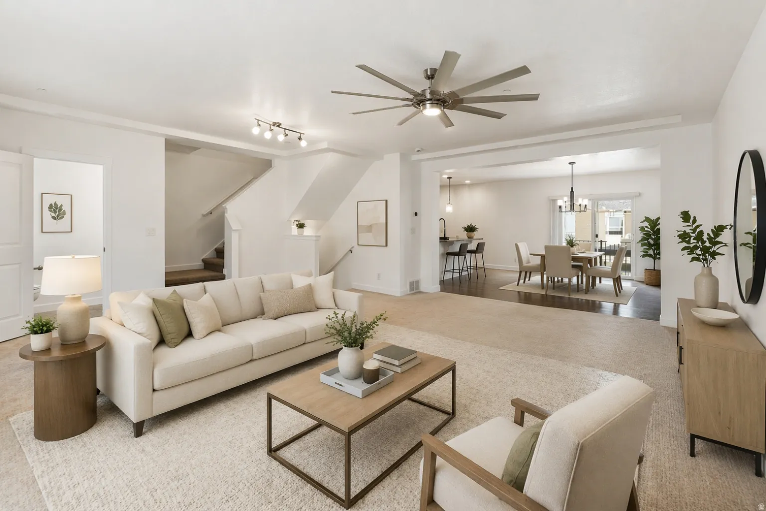 Spacious living area featuring light carpeting, a contemporary ceiling fan, and recessed lighting