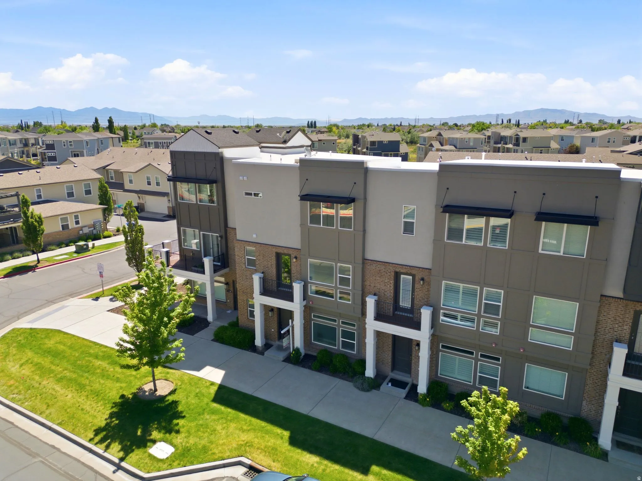 Contemporary townhome-style residences featuring multi-level facades, integrated balconies, and dark-framed windows