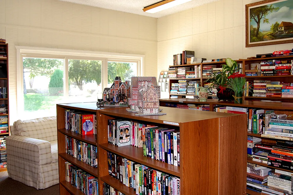 Room featuring extensive wood-finish shelving, large picture windows, and light-toned wall paneling