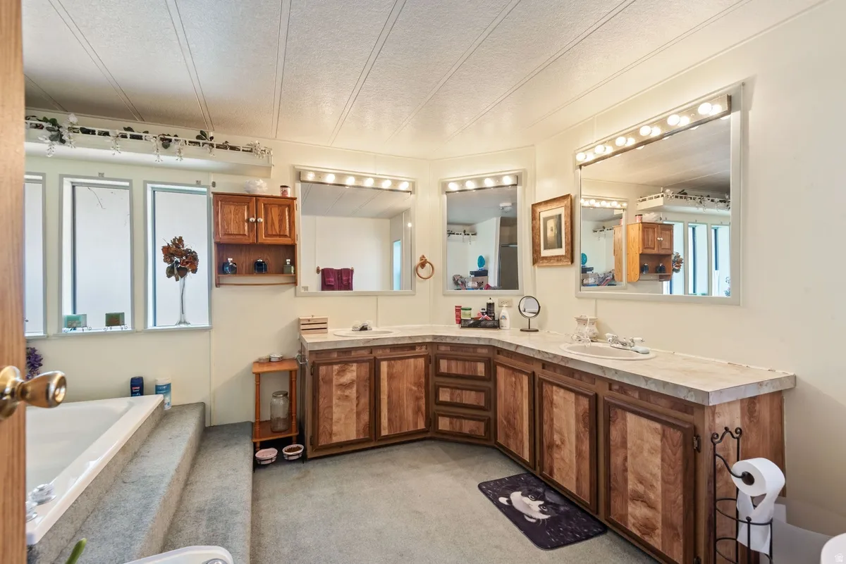 Spacious bathroom featuring a dual vanity with wood-finish cabinetry and light-toned countertops