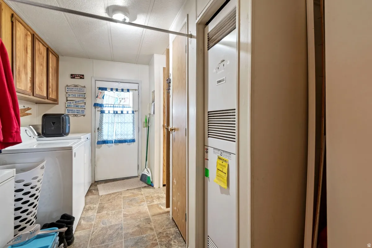 Utility area featuring wood-finish cabinetry, tile-finish flooring, and a rear exterior door