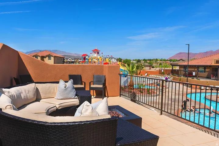 Rooftop patio featuring a built-in fire pit, paved surface, and wrought iron railing