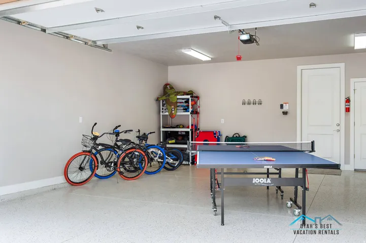 Spacious garage featuring a durable epoxy floor, overhead fluorescent lighting, and two panel doors