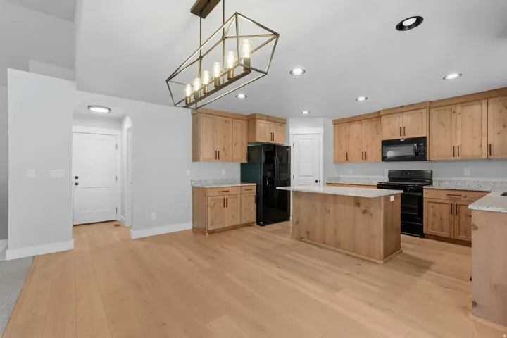 Open-concept kitchen and dining area featuring wood-finish flooring