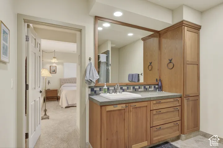 Bathroom vanity with a rectangular undermount sink, stone countertop, and wood-finish cabinetry