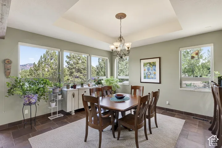 Dining area with a coffered ceiling and chandelier