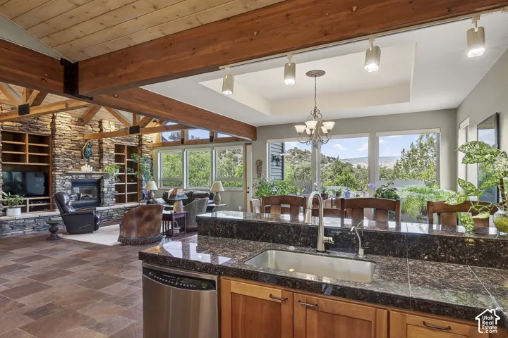 Open-concept living space with exposed wood beam ceilings and stone accent walls