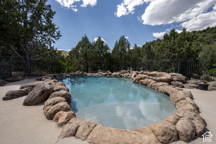 Outdoor pool featuring natural rock coping and a concrete surround