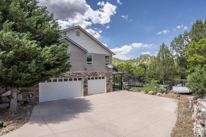Split-level exterior featuring stone veneer and horizontal siding