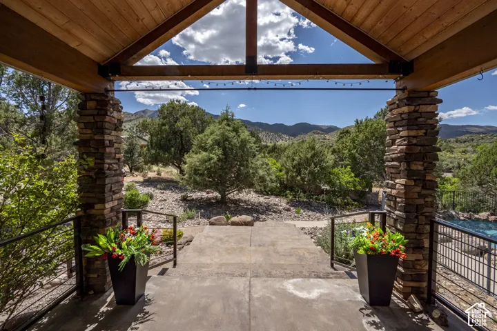 Expansive outdoor patio with natural stone columns and a wood-finish ceiling
