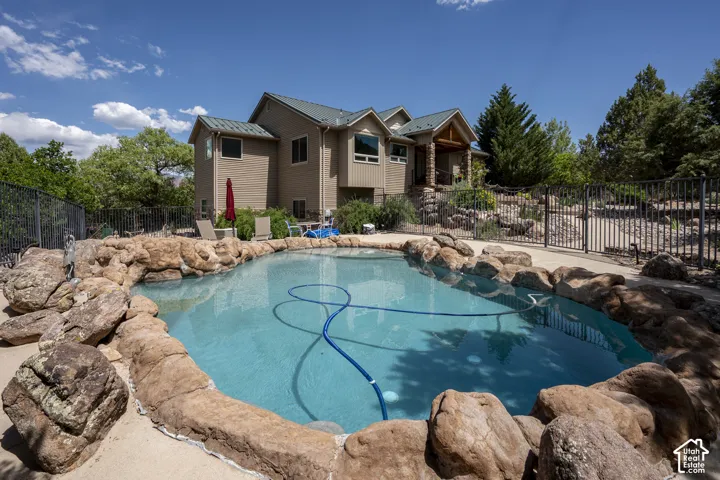 In-ground pool featuring rock coping and a concrete surround