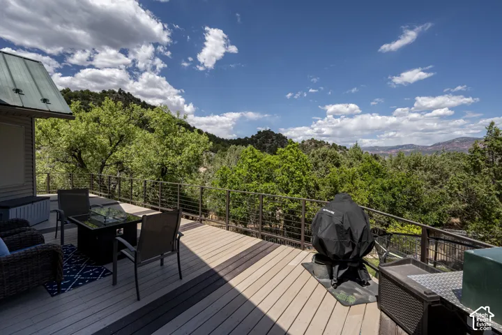 Spacious outdoor deck featuring wood-finish flooring and a metal railing system