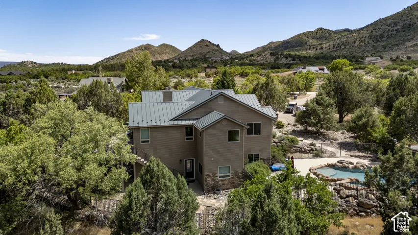 Multi-story residence featuring composite siding, a metal roof, and a stone foundation accent