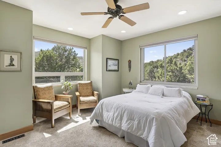 Carpeted room featuring large windows, a ceiling fan, and recessed lighting