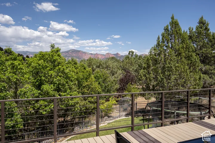 Spacious outdoor deck featuring composite wood-finish flooring and a metal cable railing system