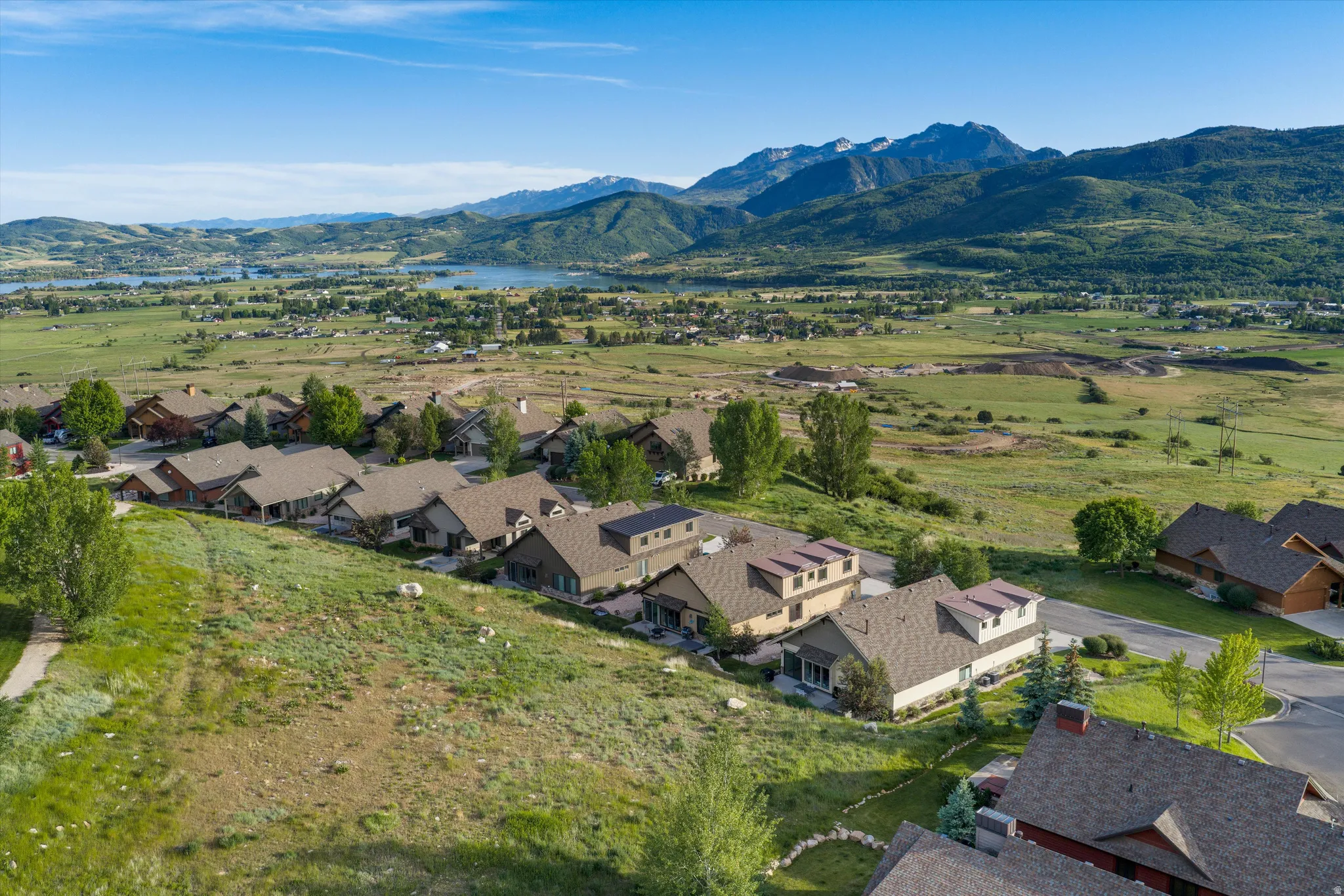 Aerial perspective showcasing a residential community with contemporary architecture, multiple homes featuring dormer windows, and a paved road