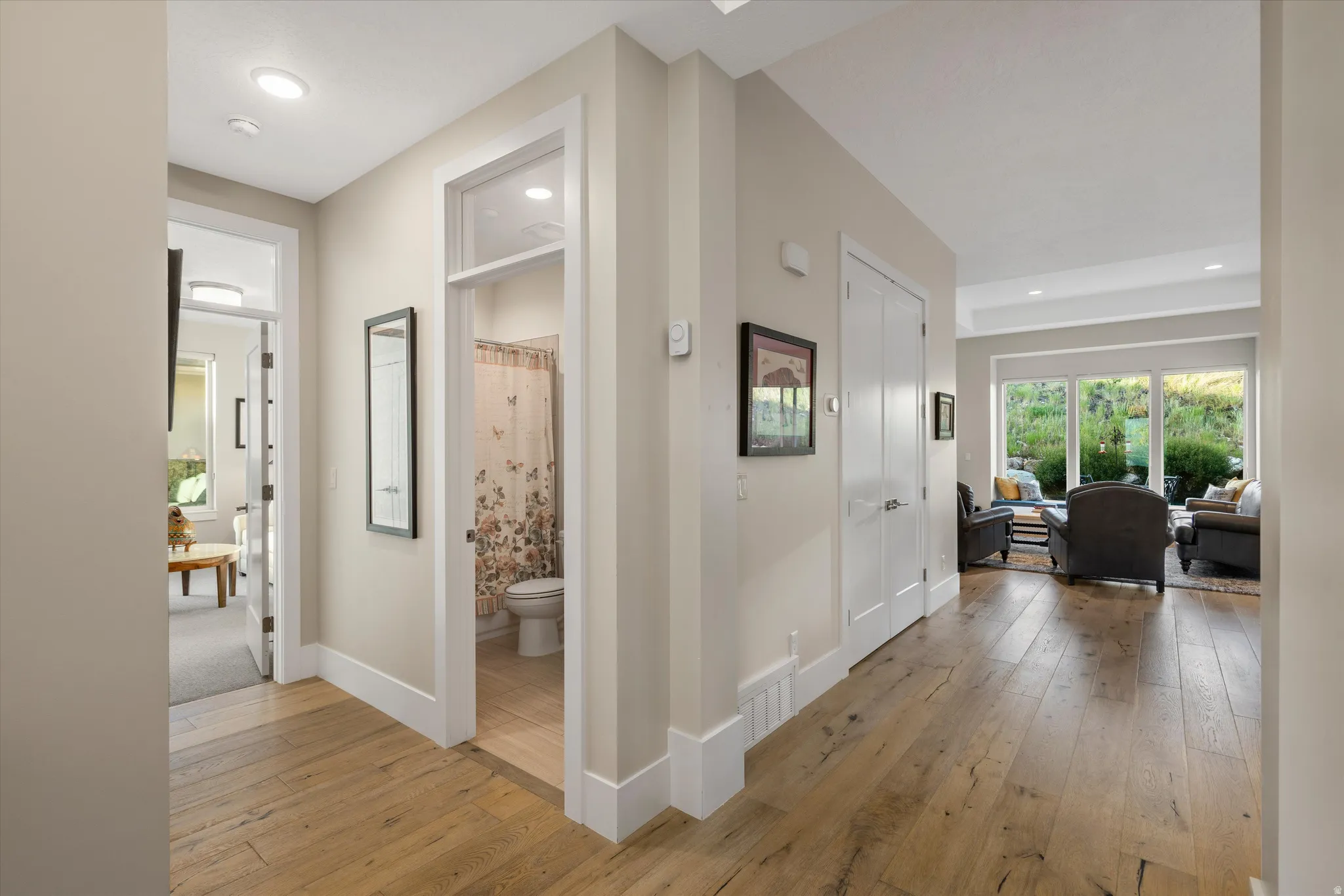 Hardwood-style flooring throughout the entry hallway, featuring recessed lighting and white trim work