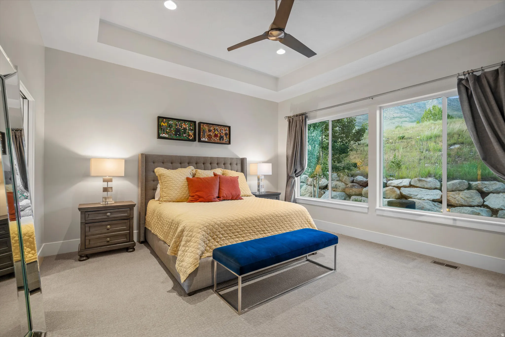 Spacious bedroom featuring large windows, tray ceiling, recessed lighting, and ceiling fan