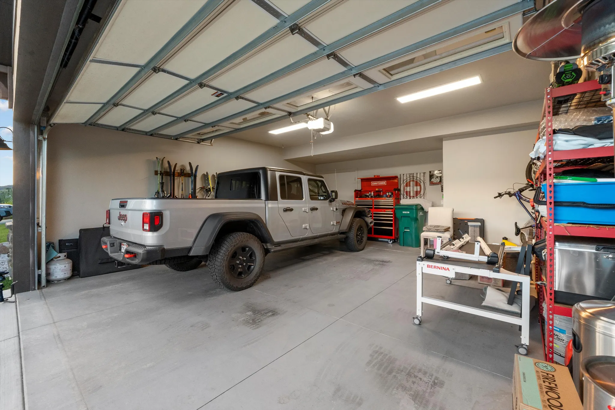 Spacious garage featuring a concrete floor, overhead lighting, and an automatic garage door opener