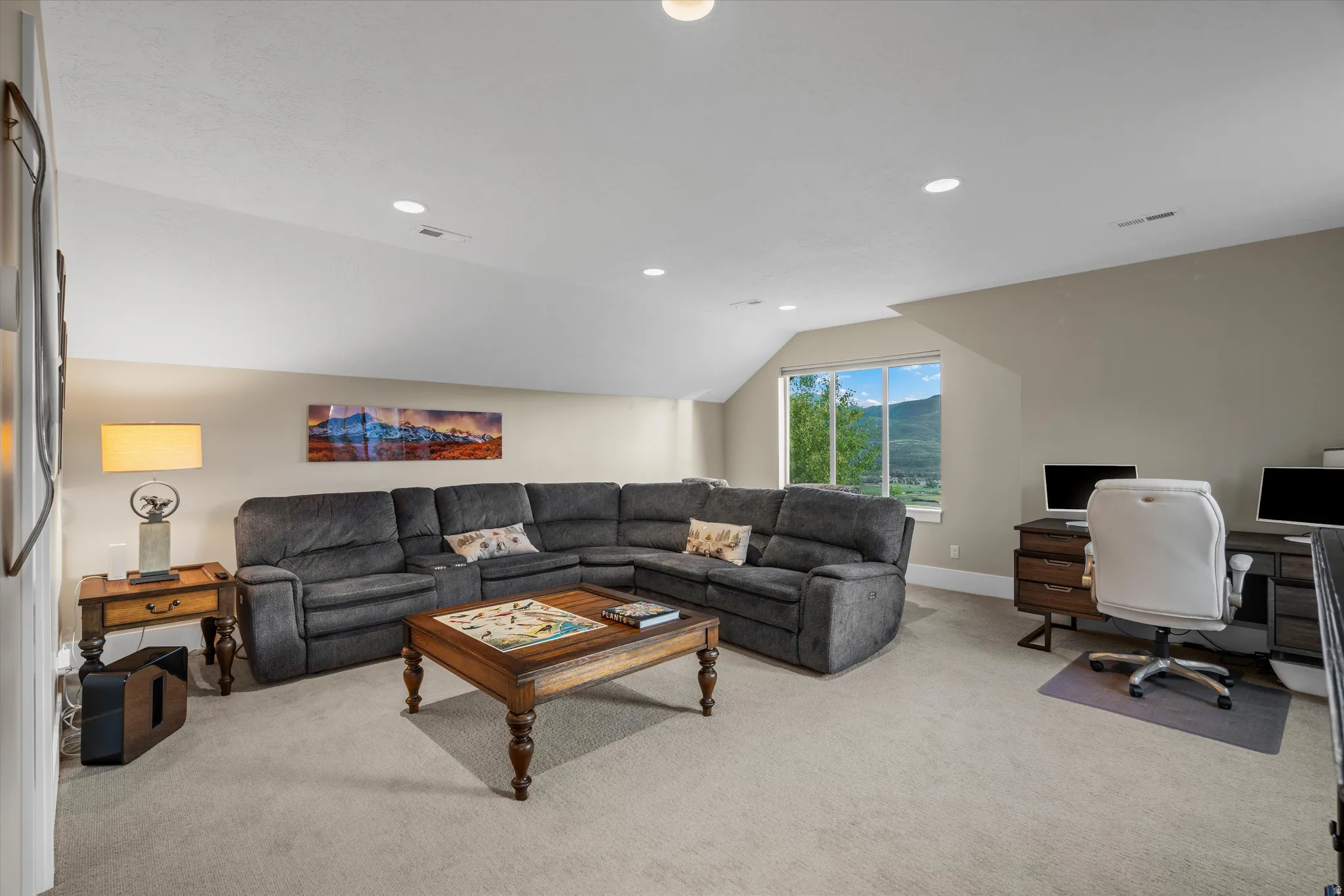 Spacious bonus room featuring neutral wall tones, recessed lighting, and a large window
