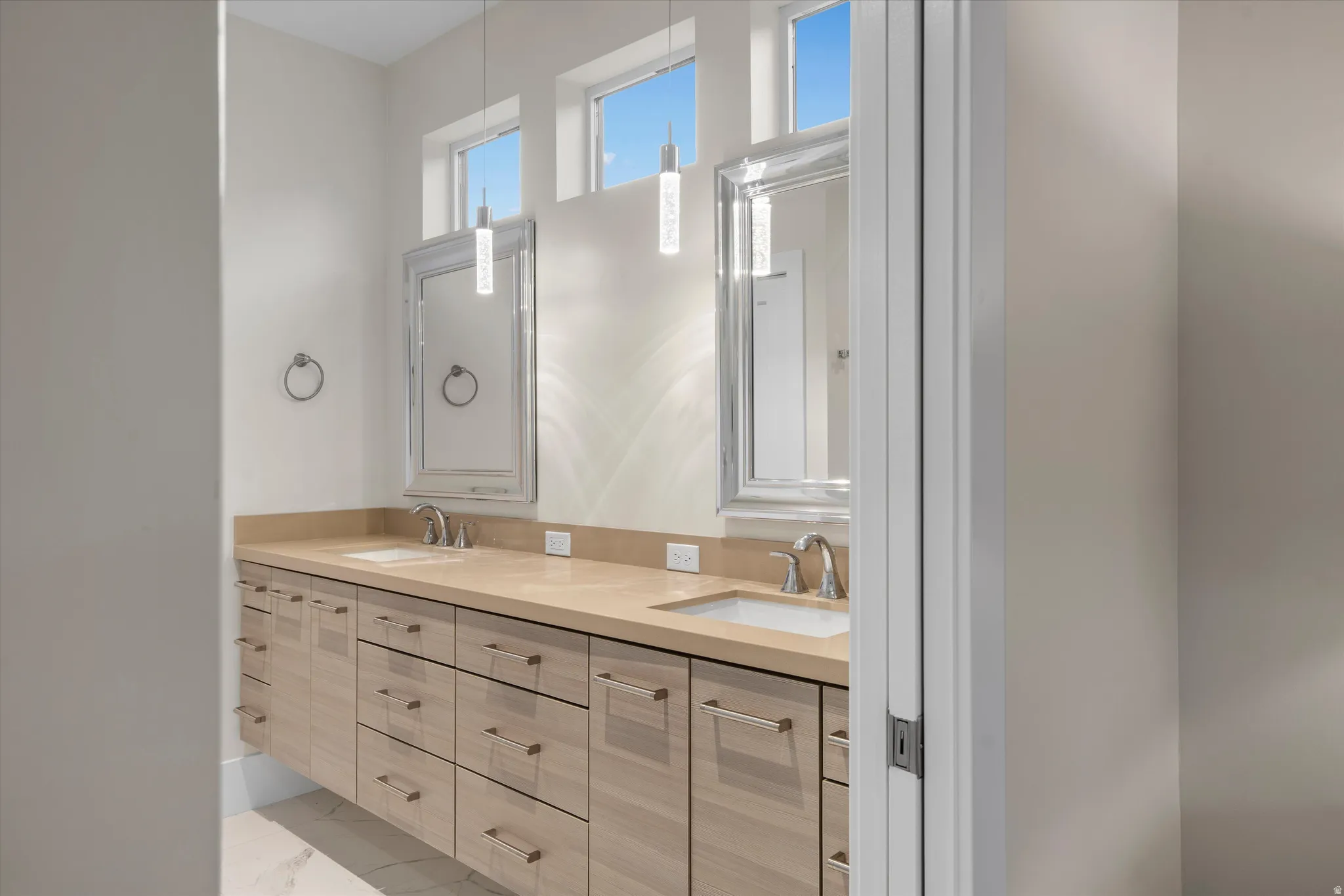 Contemporary bathroom vanity featuring dual undermount sinks set in a light-toned countertop
