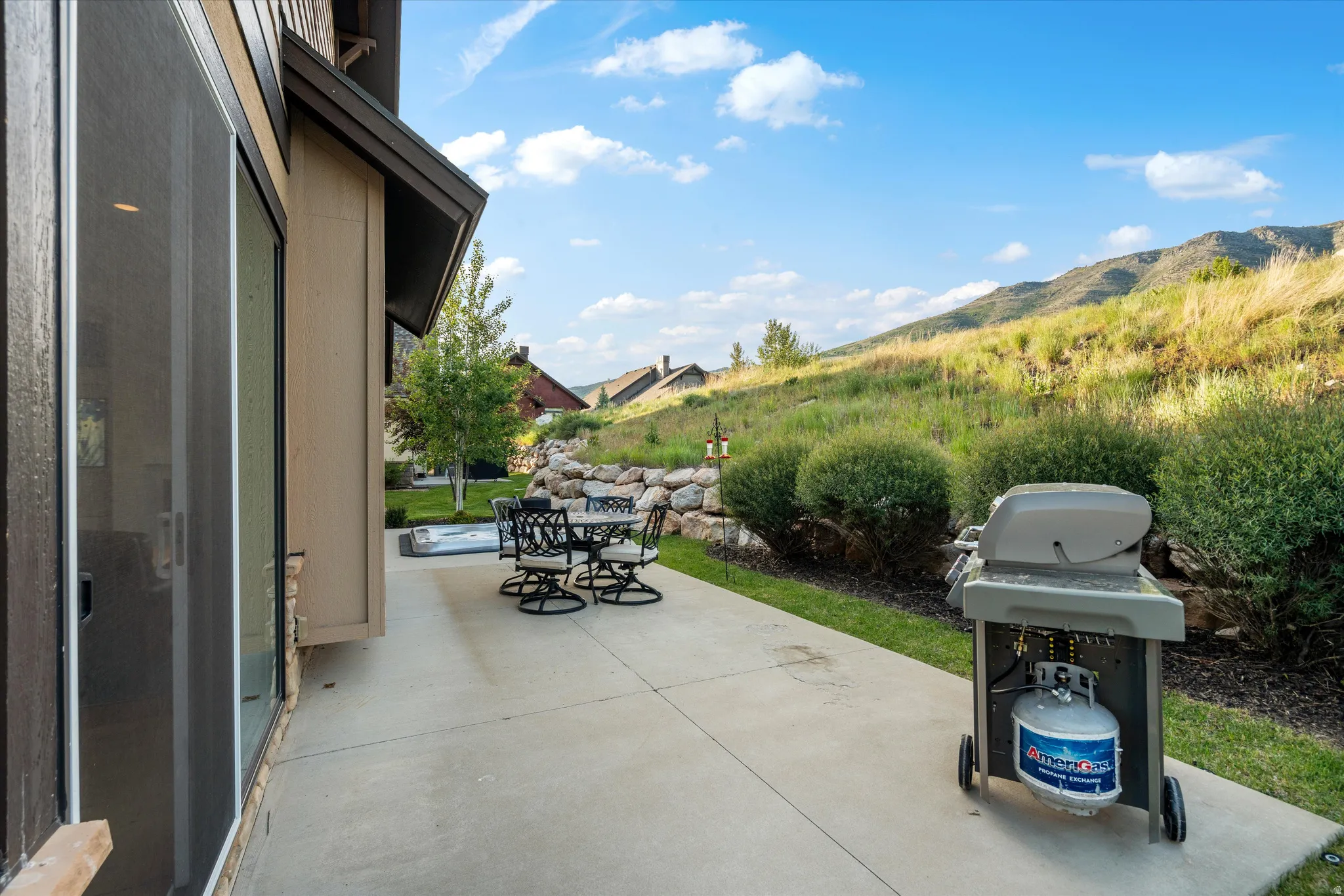 Expansive patio featuring a concrete surface and direct access to the interior via a sliding glass door