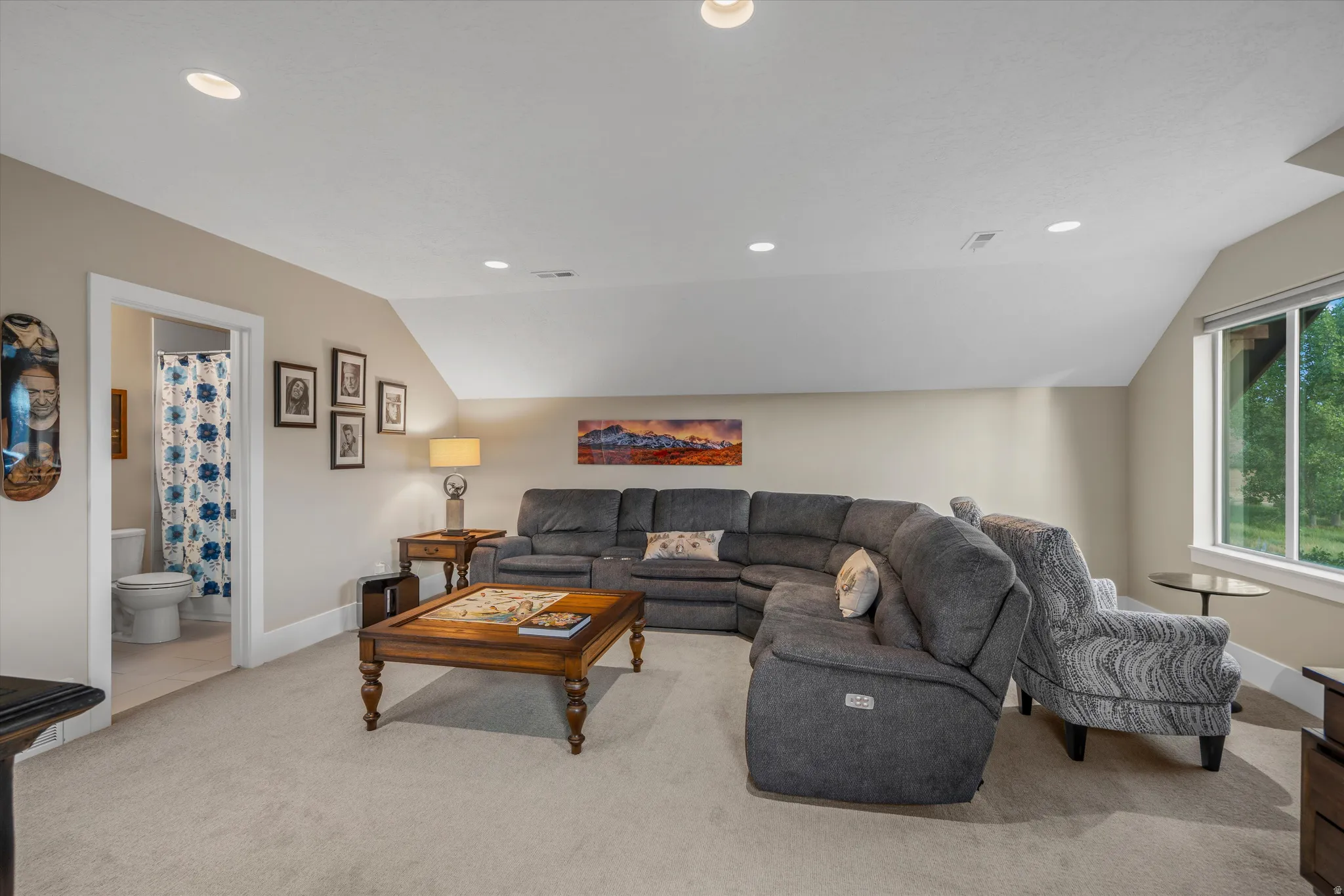 Spacious room featuring neutral carpeting, recessed lighting, and a window providing natural illumination