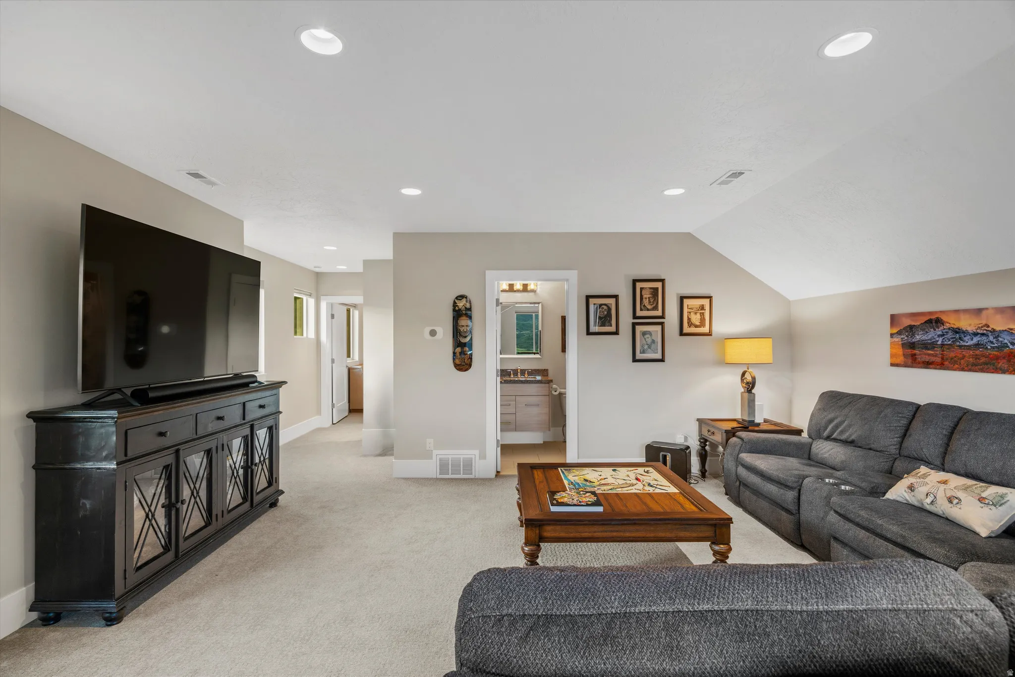 Carpeted living area featuring recessed lighting and a vaulted ceiling