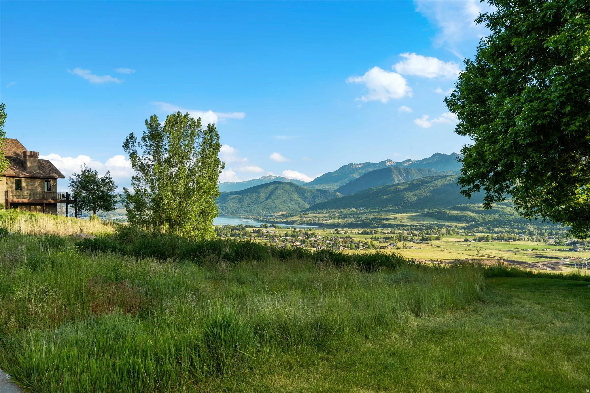 Expansive green hillside property featuring distant mountain ranges and a body of water