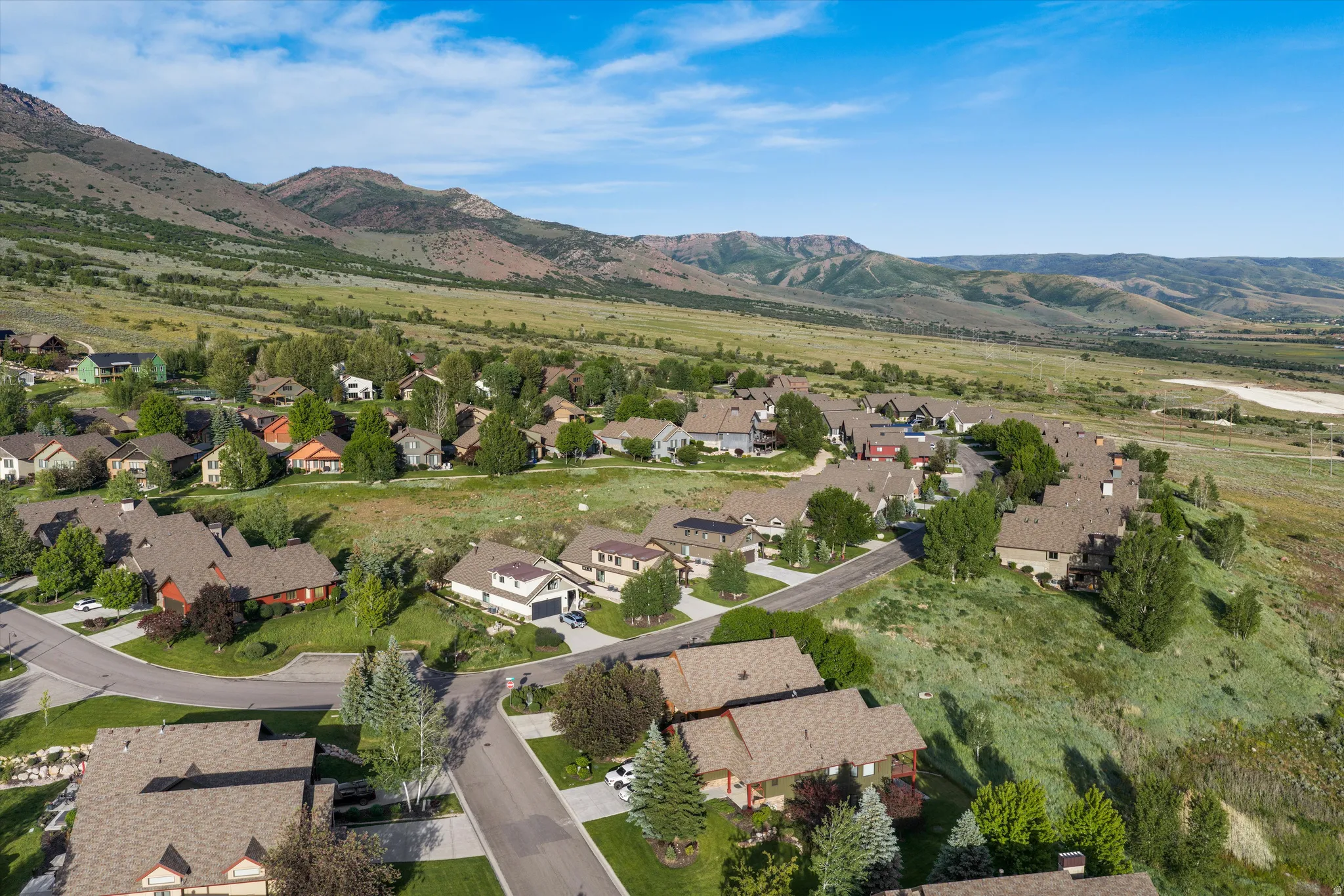 Expansive aerial showcasing a residential area nestled against a mountainous backdrop