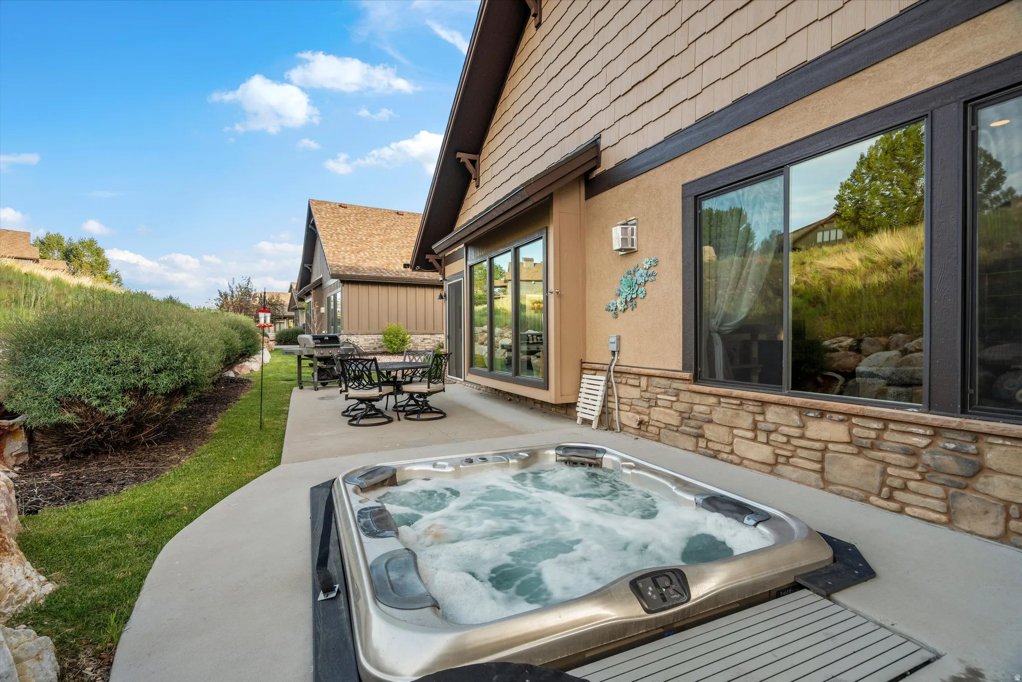 Exterior patio featuring an integrated hot tub, concrete surfacing, and a dining area