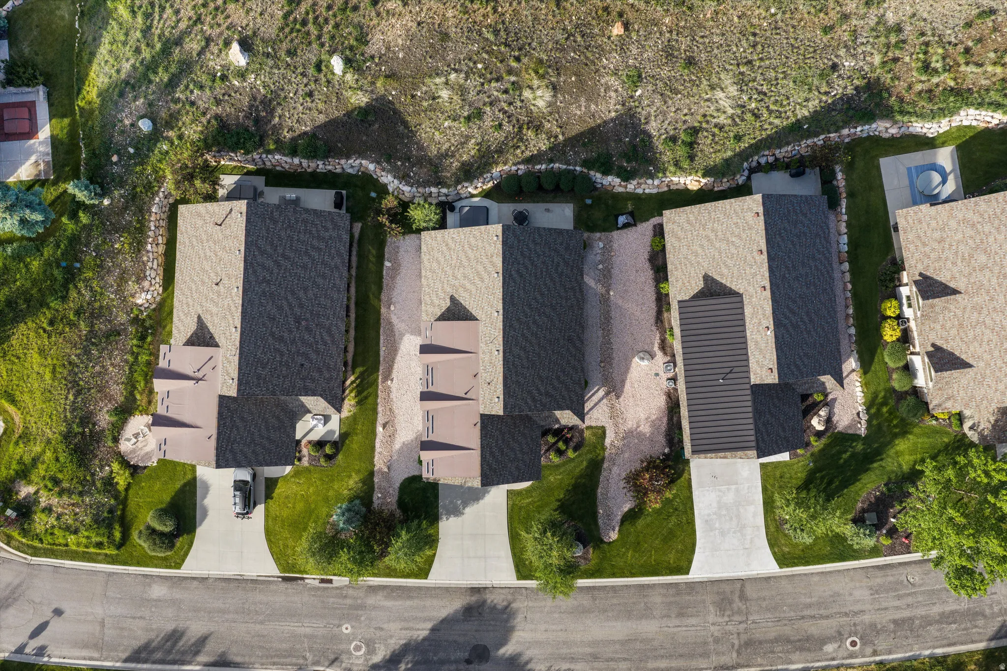 Aerial perspective showcasing properties with pitched roofs, individual driveways, and landscaped grounds