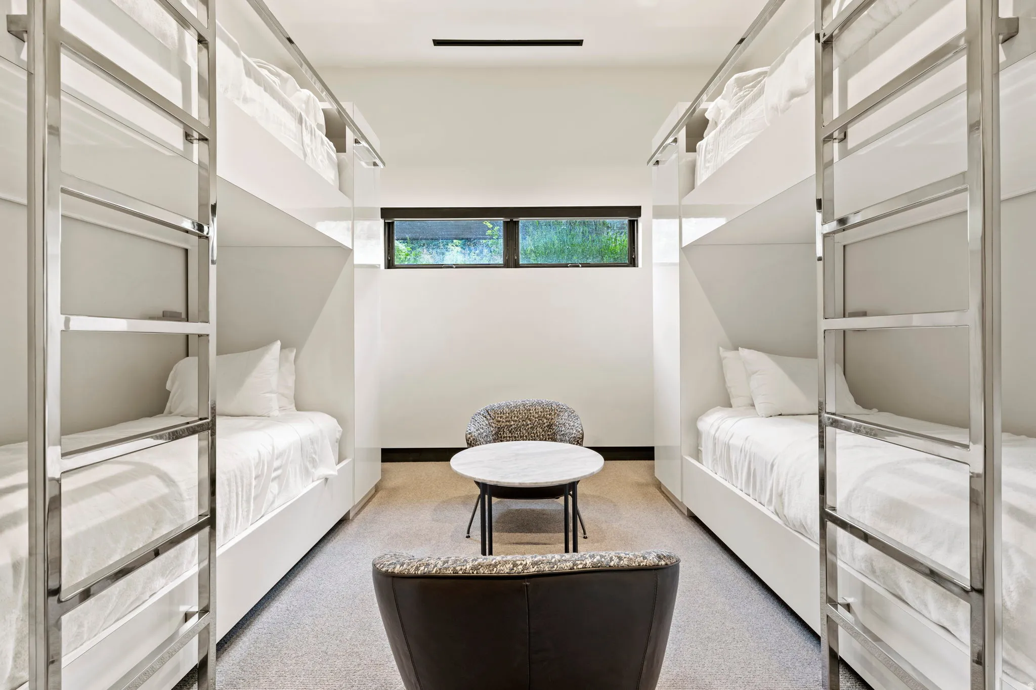 Modern bunk room featuring four built-in bunk beds with integrated ladders