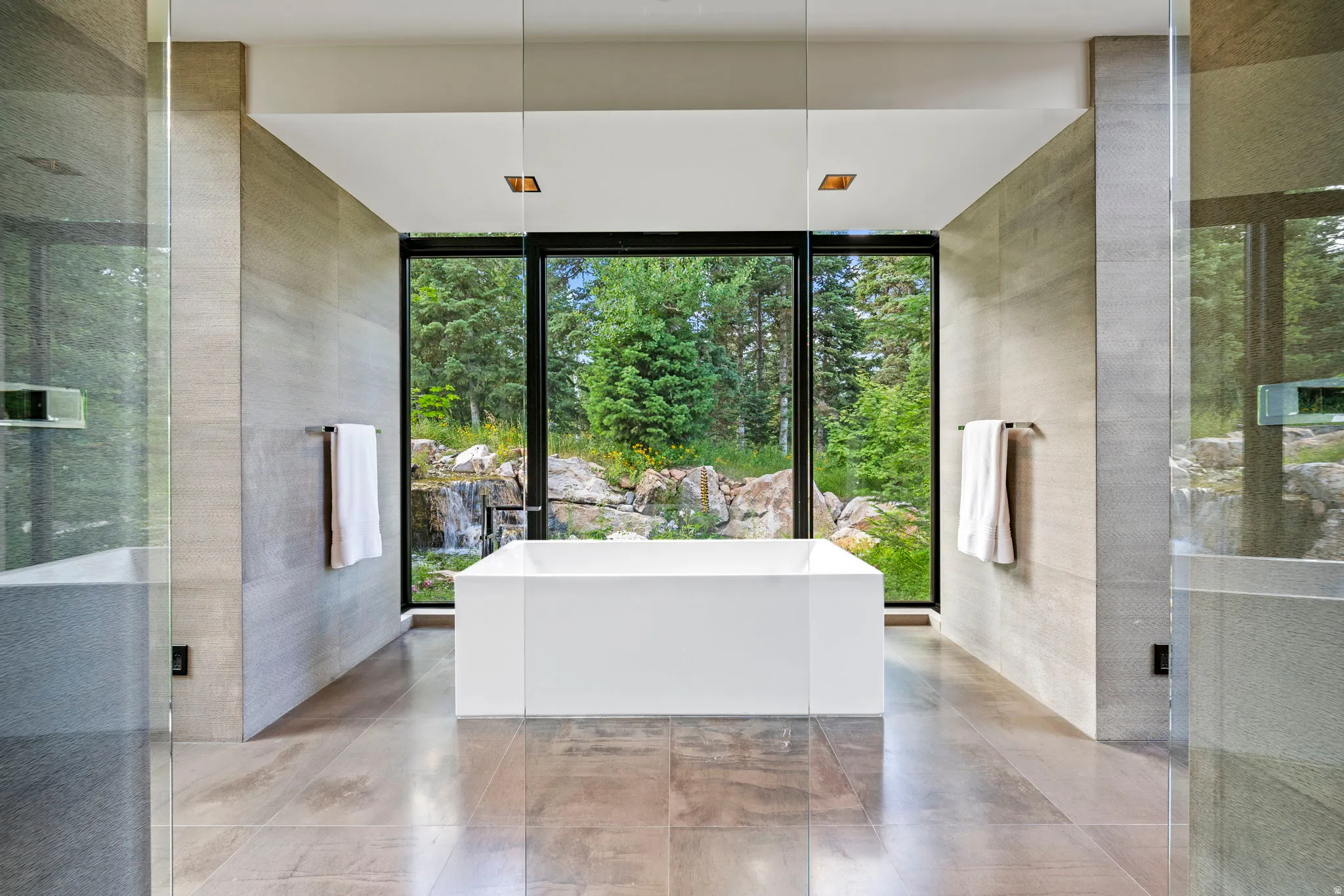 Freestanding soaking tub centered before expansive picture windows