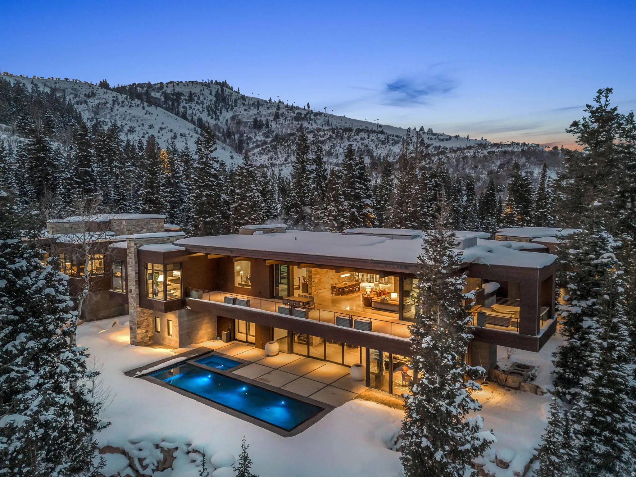 Contemporary residence featuring a multi-level design with extensive glass facade and stone accents