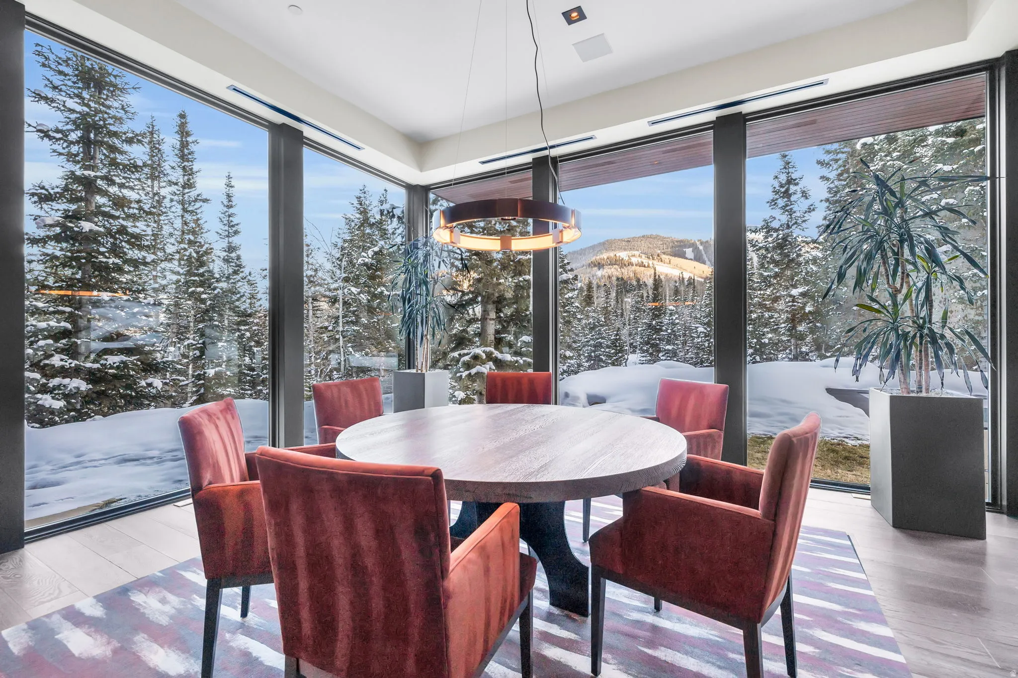 Dining area featuring expansive floor-to-ceiling windows, offering panoramic mountain scenery