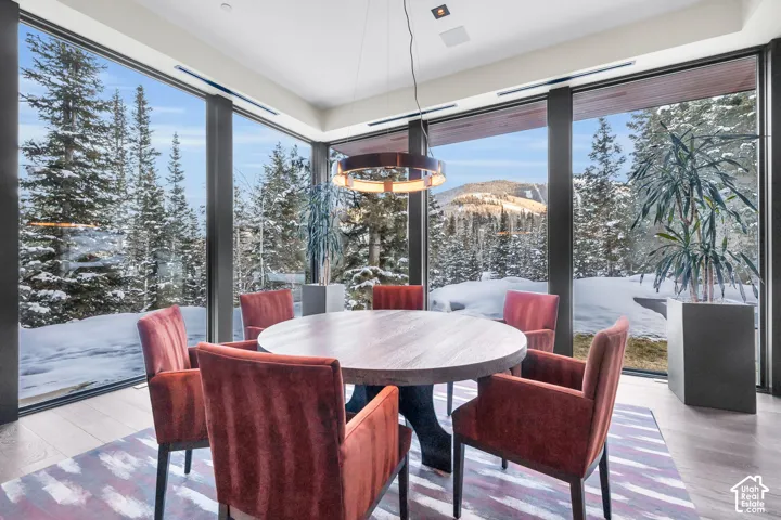 Dining area featuring expansive floor-to-ceiling windows, offering panoramic mountain scenery