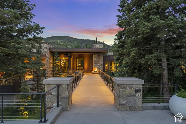 Stone and wood-clad exterior featuring a concrete entry ramp with cable railings