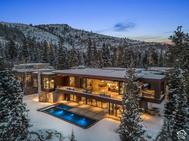 Contemporary residence featuring a multi-level design with extensive glass facade and stone accents