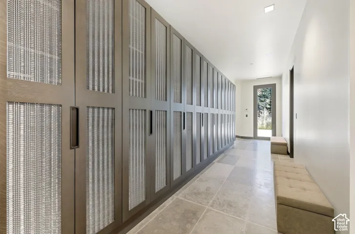 Extensive built-in cabinetry with woven panel inserts, recessed ceiling lighting, and tiled flooring