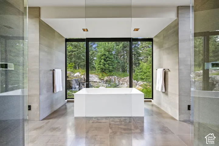 Freestanding soaking tub centered before expansive picture windows